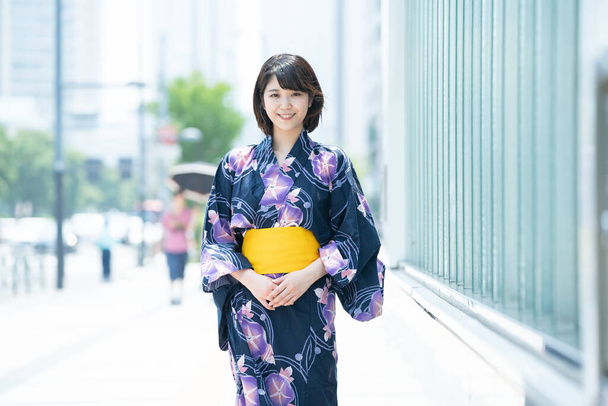 Femme asiatique (japonaise) se rendant en ville portant un yukata (costume traditionnel japonais)
) - Photo, image