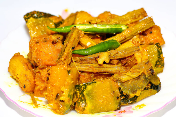 Comida vegetariana tradicional india mixta preparada con patatas, berenjenas, amaranto y calabaza en una visión macroeconómica estrecha con fondo blanco. - Foto, imagen