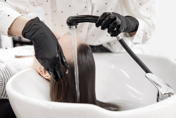 Gondoskodás a fejbőr, a haj szerkezete ellen veszteség és kopaszság. Mosási eljárás a mosogatóban. Szépségszalon spa - Fotó, kép