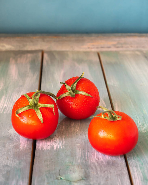 Czerwone pomidory z Mystocite leżą na drewnianym stole. Trzy dojrzałe pomidory. - Zdjęcie, obraz