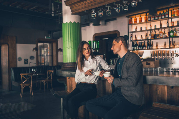 Cheerful man and woman talking, enjoying a coffee at the coffee shop, cafe, bar - Photo, image