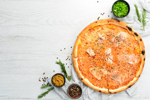 Pizza with salmon and tomato sauce. Italian cuisine. Food delivery. Top view. - Foto, afbeelding
