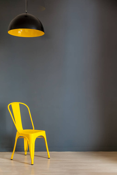Salon mur maquette avec mur gris foncé et chaise et lampe jaune audacieux
 - Photo, image