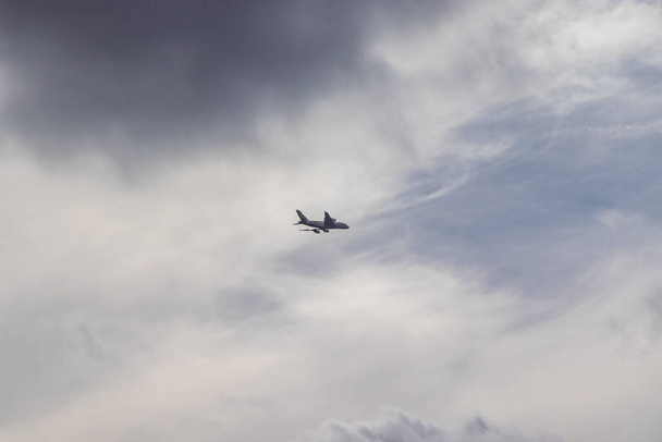 Airplane in the cloudy sky - Passenger Airliner aircraft, London, England - Photo, Image