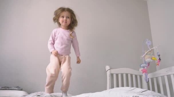 Vicces és boldog lány ugrál az ágyon - Felvétel, videó