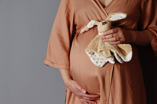 ベージュのドレスを着た妊婦クロップドビュー   - 写真・画像
