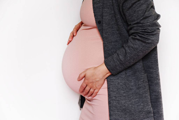 terhes nő rózsaszín ruhában, kivágott nézet   - Fotó, kép