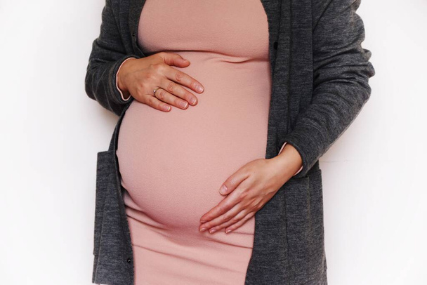 pregnant woman in pink dress, cropped view   - Zdjęcie, obraz