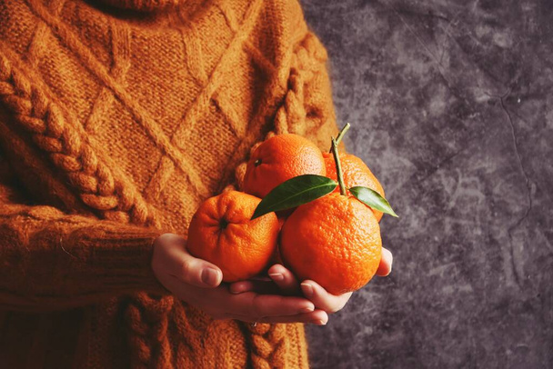 nő pulóverben narancs a kezében, vágott kilátás  - Fotó, kép