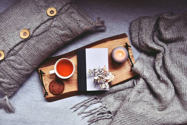 Άνετο σπίτι με φλιτζάνι τσάι, καρό και κερί   - Φωτογραφία, εικόνα