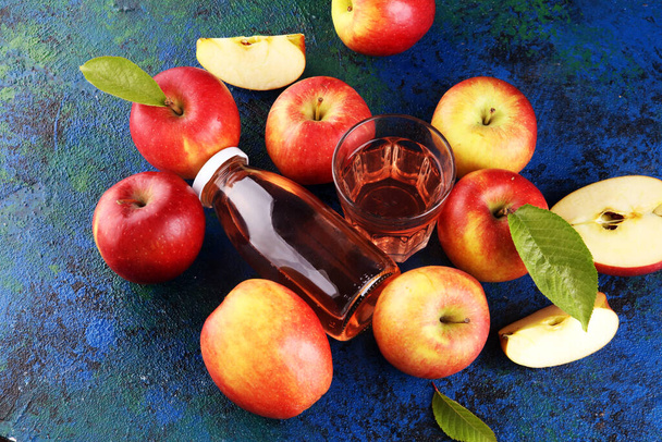 Boisson au cidre de pomme et pommes aux feuilles sur table rustique
 - Photo, image