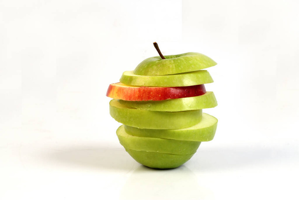 plasterki czerwonego i zielonego jabłka na białym podłożu  - Zdjęcie, obraz