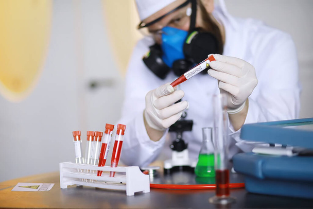 Laboratuvardaki bir bilim adamı viral zatürreenin tedavisi için ilaçları test ediyor. Hastalıklı hastaların Coronovirus kan testi. Dünya salgını. - Fotoğraf, Görsel