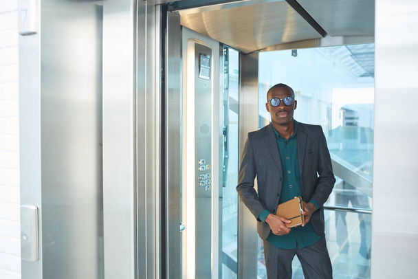 Empresário de pé no elevador
 - Foto, Imagem