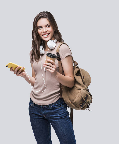 Young beautiful student girl with smart phone and rucksack - Fotoğraf, Görsel