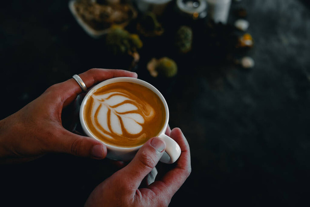 Ręce trzymając filiżankę kawy latte art - Zdjęcie, obraz