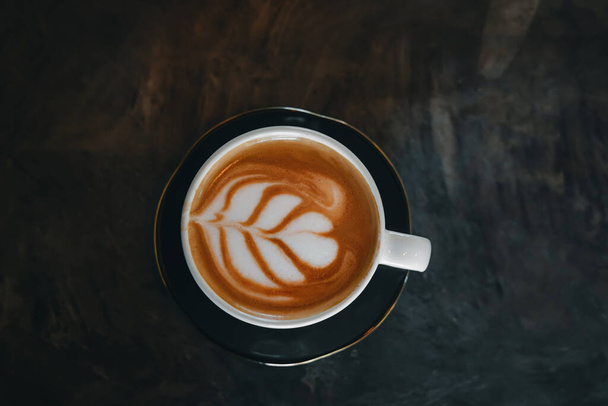Tasse à café avec latte art sur une vieille table, vue sur le dessus
. - Photo, image