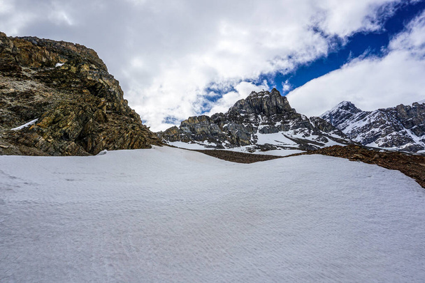 Snowcapped Kanadské Skalnaté hory během letního dne kontrastující s jasně modrou oblohou a bílými mraky - Fotografie, Obrázek