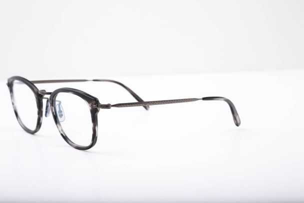 A closeup shot of black and white patterned eyeglass on a white background - Zdjęcie, obraz