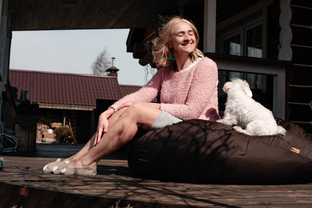 attractive woman with dog sitting on patio - Zdjęcie, obraz