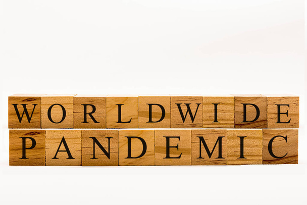Coronavirus concept showing wooden blocks on a white background reading Worldwide Pandemic - Foto, Bild