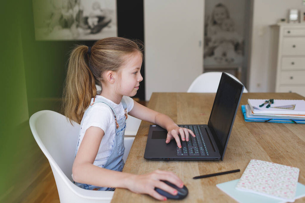 girl working on her laptop during home schooling during corona crisis - Fotó, kép
