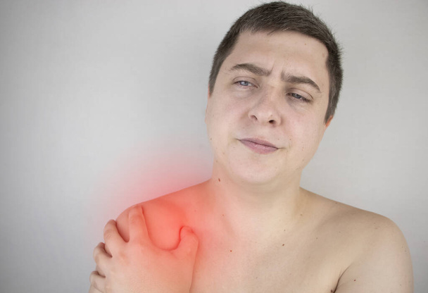 Ένας άνθρωπος υποφέρει από πόνο στον ώμο. Τραυματισμός ώμου, τενοντίτιδα, διάστρεμμα ή φλεγμονή τένοντα. Η έννοια του οξέος πόνου και της φλεγμονής σε διάφορα μέρη του σώματος - Φωτογραφία, εικόνα
