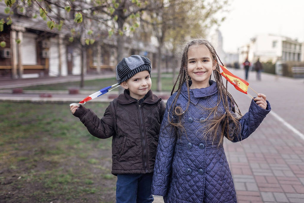Niños felices que se quitan la máscara respiratoria médica en Francia y España bandera colores debido al fin de la cuarentena en el país, la felicidad y la esperanza, detener la propagación del virus, estilo de vida al aire libre
 - Foto, Imagen