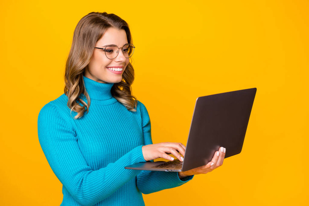 Photo of attractive charming wavy lady hold modern technology notebook reading corporate report online email wear specs blue turtleneck isolated bright yellow color background - Фото, зображення