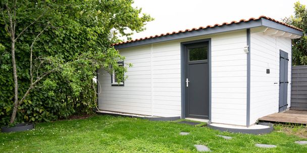 casa pequeña de madera jardín de césped verde casa pequeña de madera blanca
 - Foto, Imagen