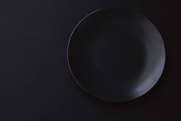 Leere Teller auf schwarzem Hintergrund, hochwertiges Geschirr für das Festtagsessen, minimalistisches Design und Ernährung - Foto, Bild
