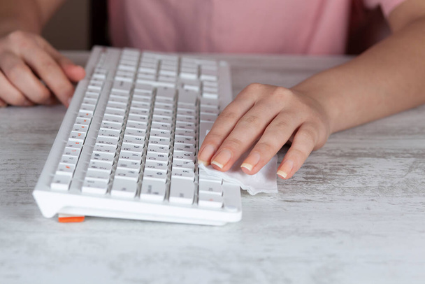 Woman cleaning pc keyboard. Coronavirus prevention measures - Foto, immagini