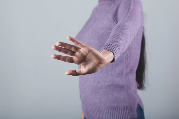 sad woman hand stop sign on gray background - Фото, изображение