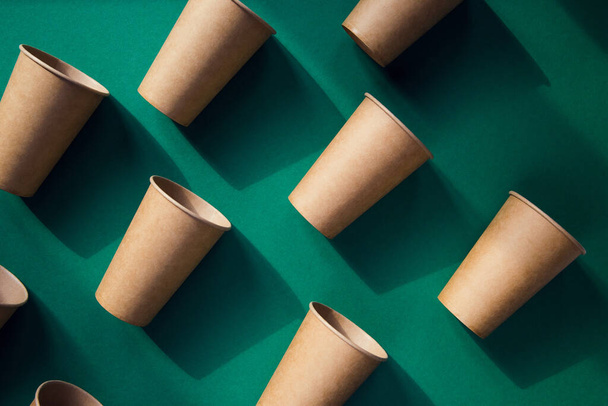 Tasses en papier artisanal respectueux de l'environnement sur fond vert. Concept de recyclage. Thème zéro déchet - Photo, image