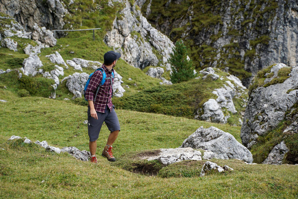 Caminhante esportivo jovem andando em frente ao íngreme distintivo Pieralongia Rocks em Puez Odles Naturepark no sul do Tirol / Gardena Valley / Dolomites
 - Foto, Imagem