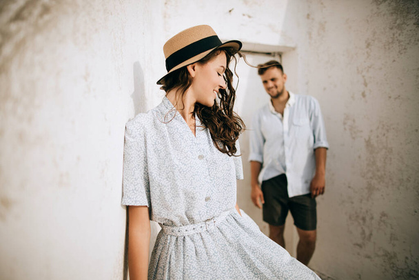 Young loving couple in summer clothes near white wall - Photo, Image