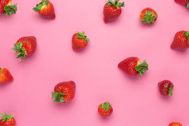 Ripe juicy strawberries on a pink background. pattern, Fresh berry flat lay. Creative Minimal food concept - Foto, imagen