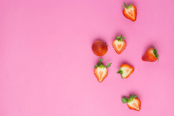 ピンクの背景に隔離されたイチゴ。新鮮なベリーフラットレイ。創造的な最小限の食品コンセプト - 写真・画像