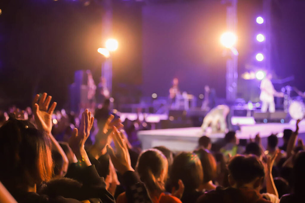 El kaldırarak Soyut Canlı konserinin odaklanmasını engelledi. Konser kalabalığının siluetleri önünde - Fotoğraf, Görsel