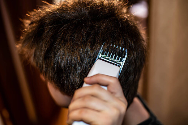Coupe de cheveux avec une tondeuse à cheveux à la maison
 - Photo, image