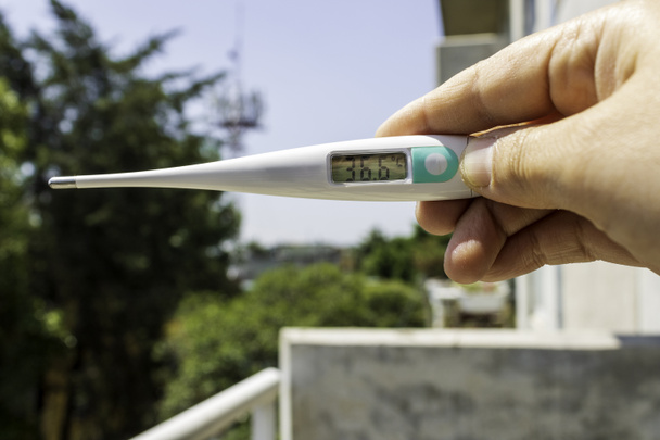Persona sosteniendo un termómetro en su balcón
 - Foto, imagen