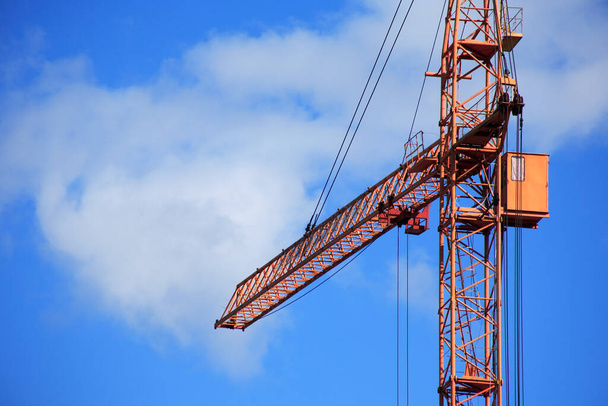 Průmyslové téma. Žlutý stavební jeřáb proti modré obloze - Fotografie, Obrázek
