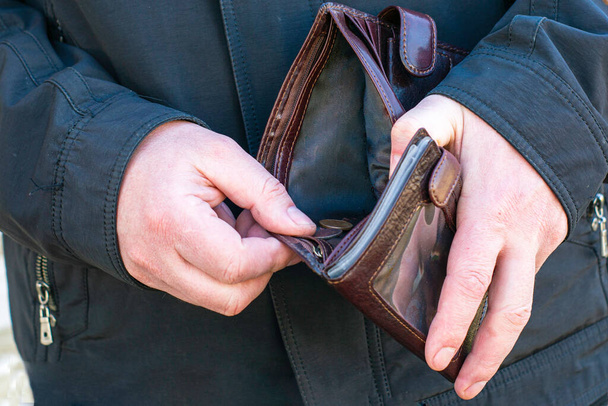 käsite talouskriisi köyhyys ihminen avaa lompakko, jossa on vain muutamia kolikoita
 - Valokuva, kuva