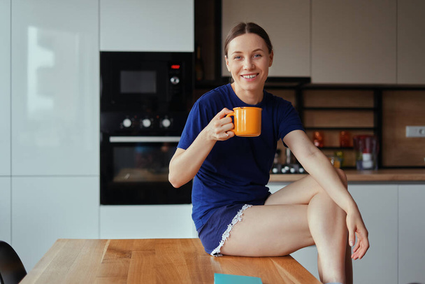 Lovely woman drinking a cup of tea in the kitchen - Foto, immagini