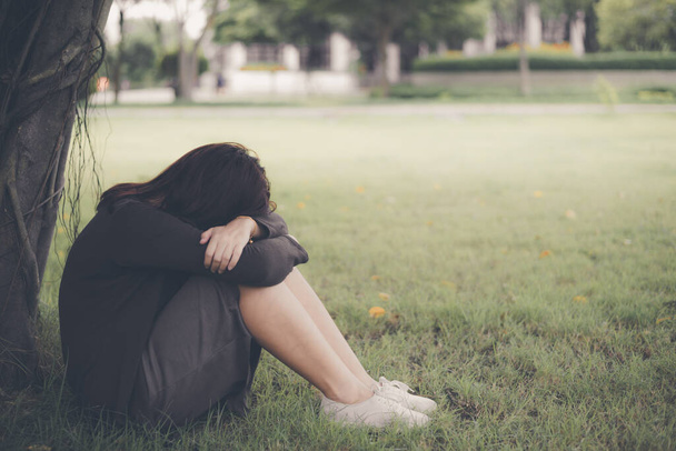 Азиатка, сидящая одна и подавленная, Портрет уставшей молодой женщины. Депрессия - Фото, изображение