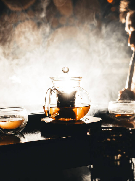A pot of tea in a lounge, illuminated with bright light and filled with hookah steam on background - Fotografie, Obrázek
