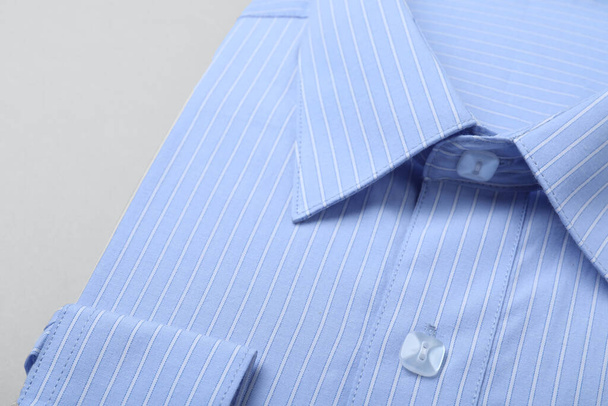 Stylish light blue shirt on white background, closeup. Dry-cleaning service - Photo, image
