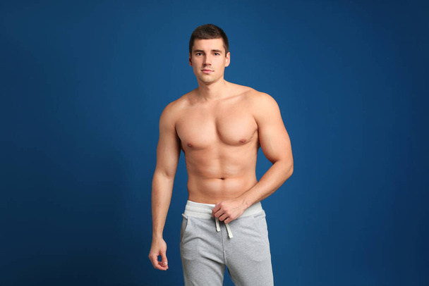 Man with sexy body on blue background - Foto, afbeelding