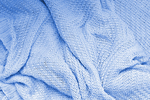 Текстура синего трикотажного одеяла. Абстрактный фон. Большая петля. Натуральные хлопковые нити. Вид с вершины. Смятая поверхность
 - Фото, изображение