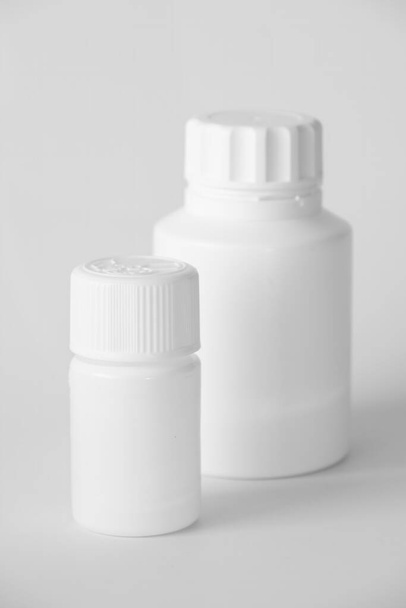 White Plastic Pill Bottles On A Gray Surface - 写真・画像